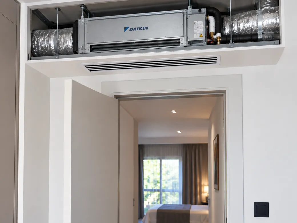 Unité gainable Daikin intégrée dans un faux plafond au-dessus d'une porte